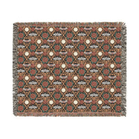 Victorian Gothmas Woven Blanket with candlelight-inspired colors and colorful fringed edges on a dark velvet background