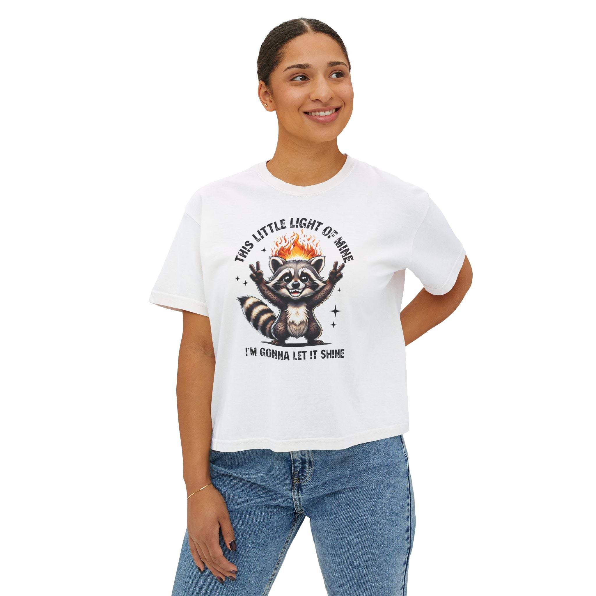 Woman wearing white "This Little Light of Mine" boxy tee with raccoon graphic and jeans