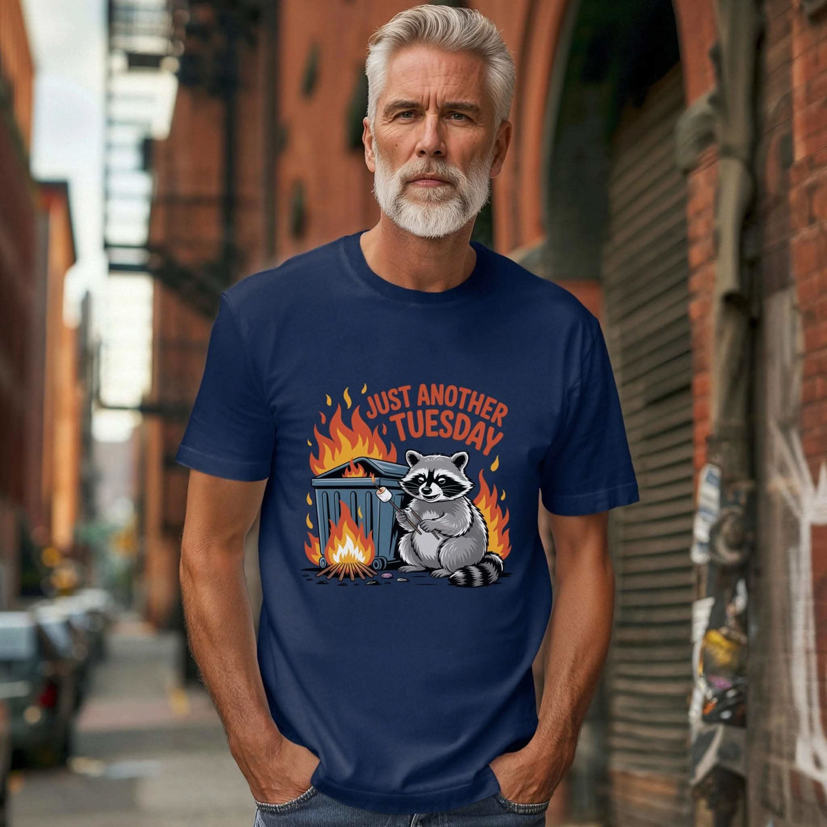 Raccoon Dumpster Fire T-shirt featuring playful raccoon with small dumpster fire and "Just Another Tuesday" caption on vintage-style cotton shirt