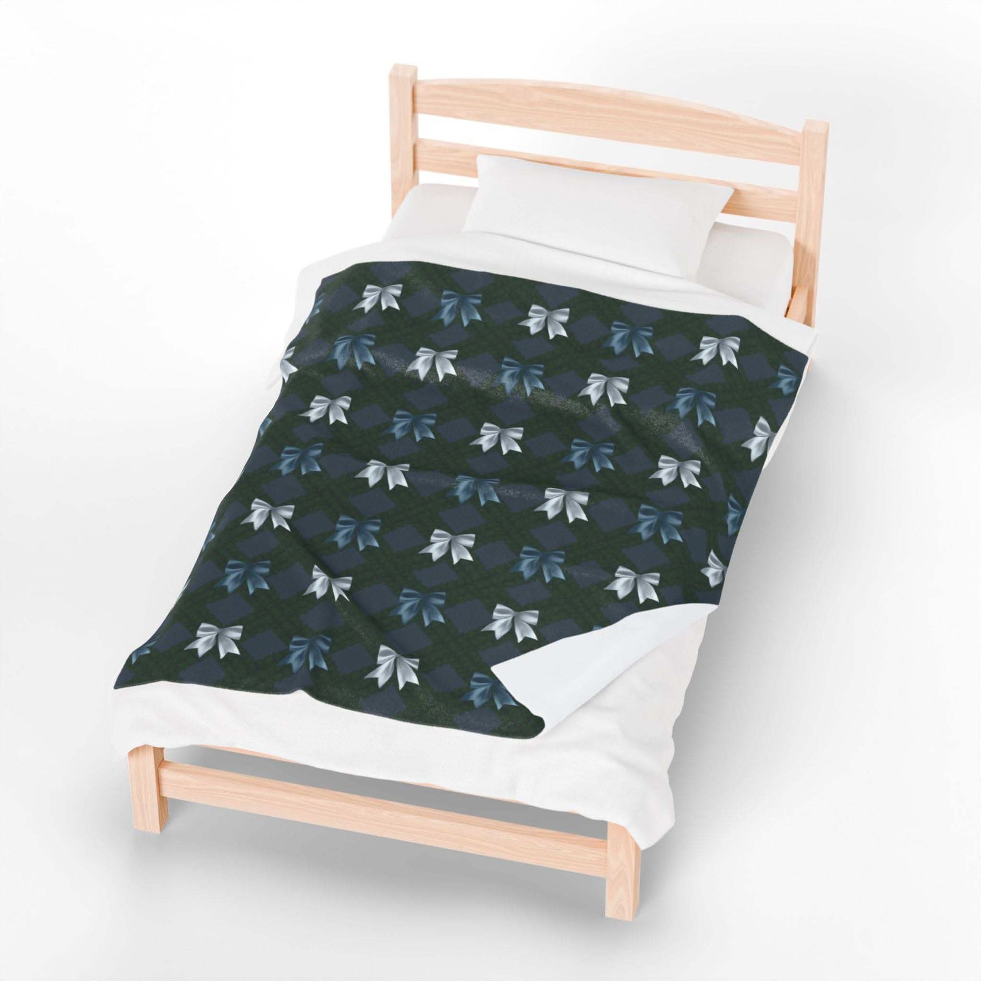 Velveteen plush blanket with winter coquette bows design on wooden bed