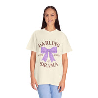 Woman wearing a cream t-shirt with a purple bow and text on a white background