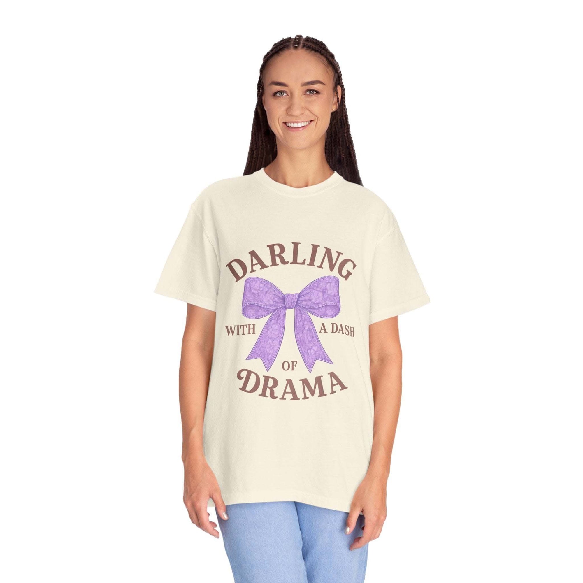 Woman wearing a cream t-shirt with a purple bow and text on a white background
