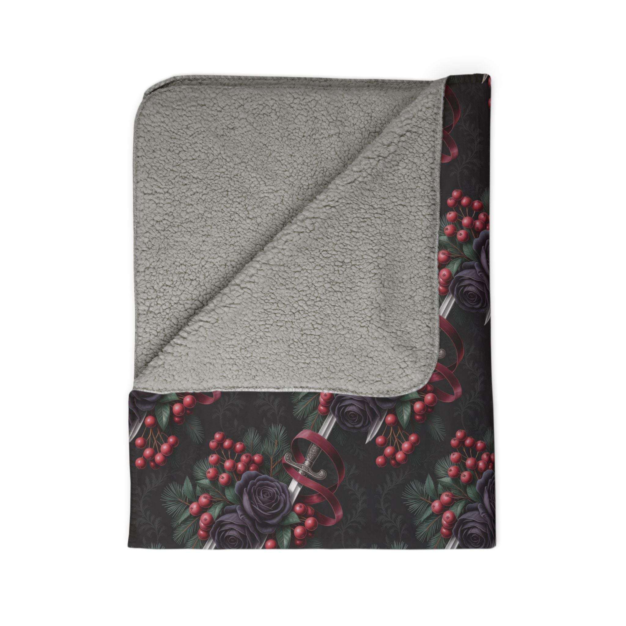 Folded Gothmas Black Roses & Daggers fleece sherpa blanket with black rose and dagger print and gray sherpa lining