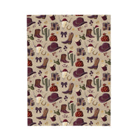 Plush blanket with cowboy Christmas design featuring hats, boots, cacti, and festive gifts in vibrant colors