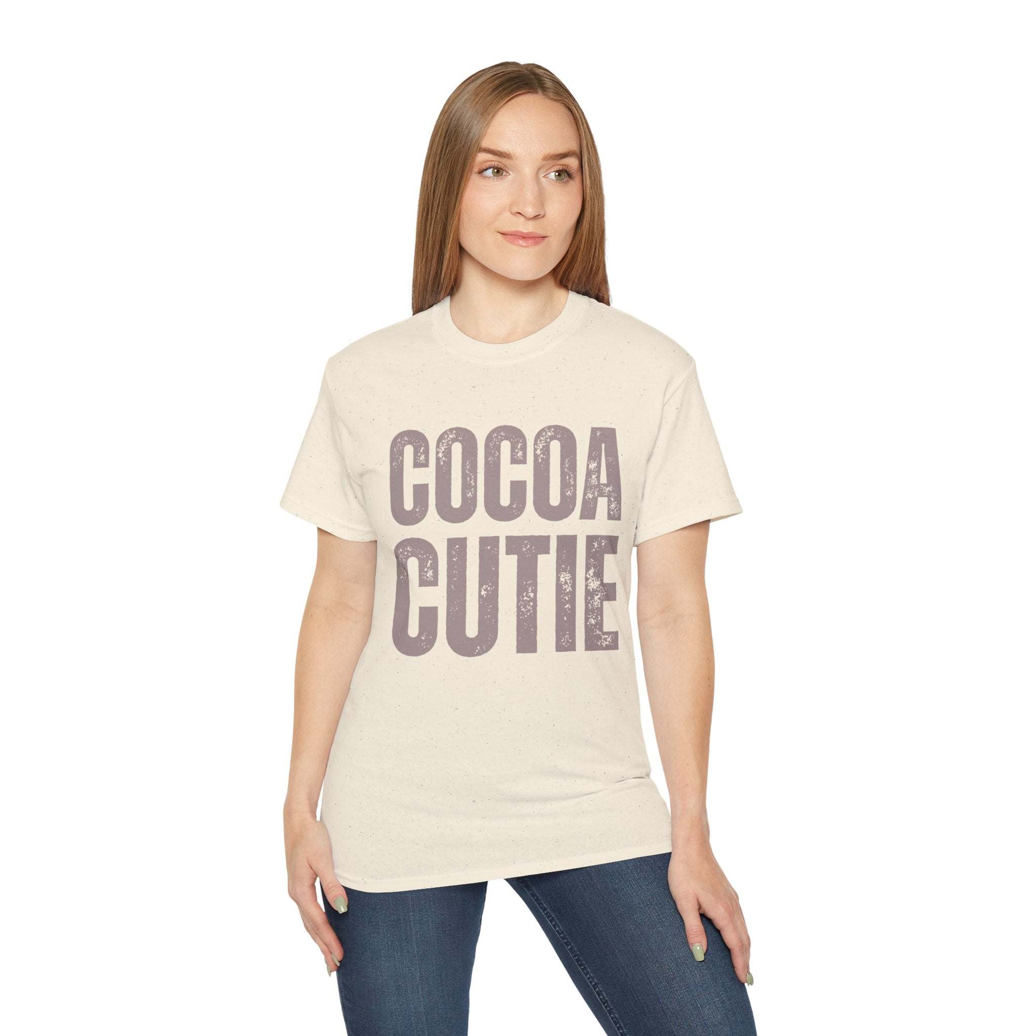 Woman wearing distressed cocoa cutie tee in vintage cream cotton with bold text design