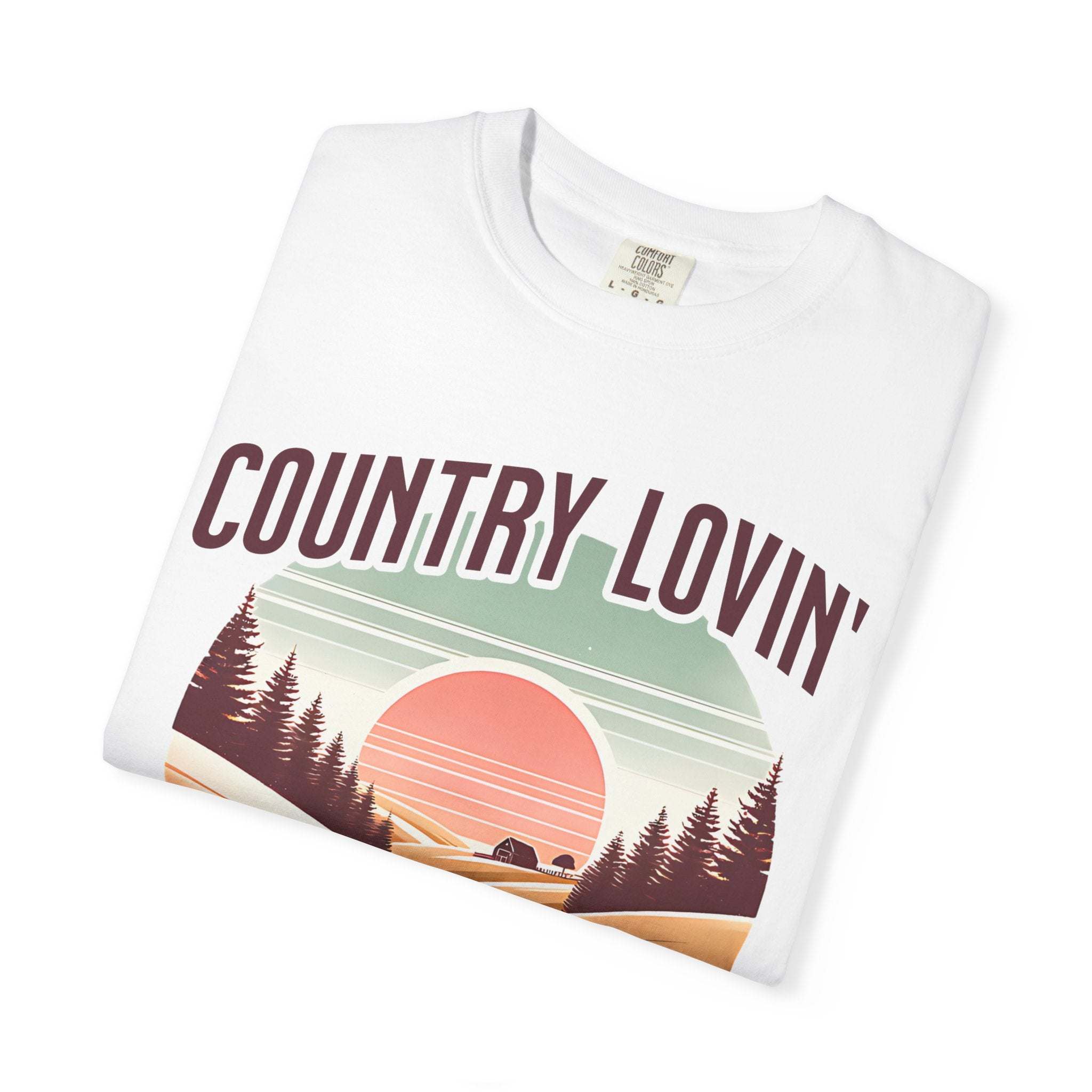 Folded white Country Lovin Girl T-shirt with vintage sunset and forest graphic design