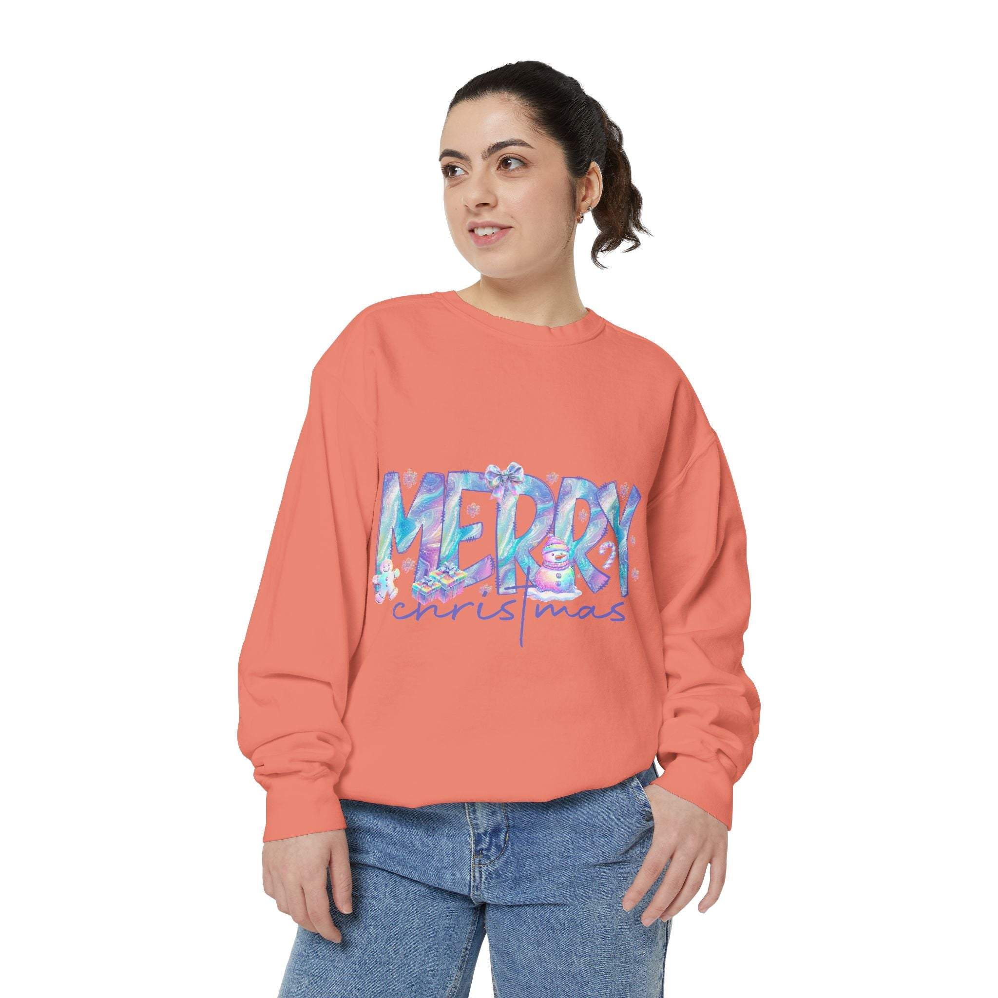 Woman wearing coral iridescent Merry Christmas sweatshirt with relaxed fit and ribbed cuffs.
