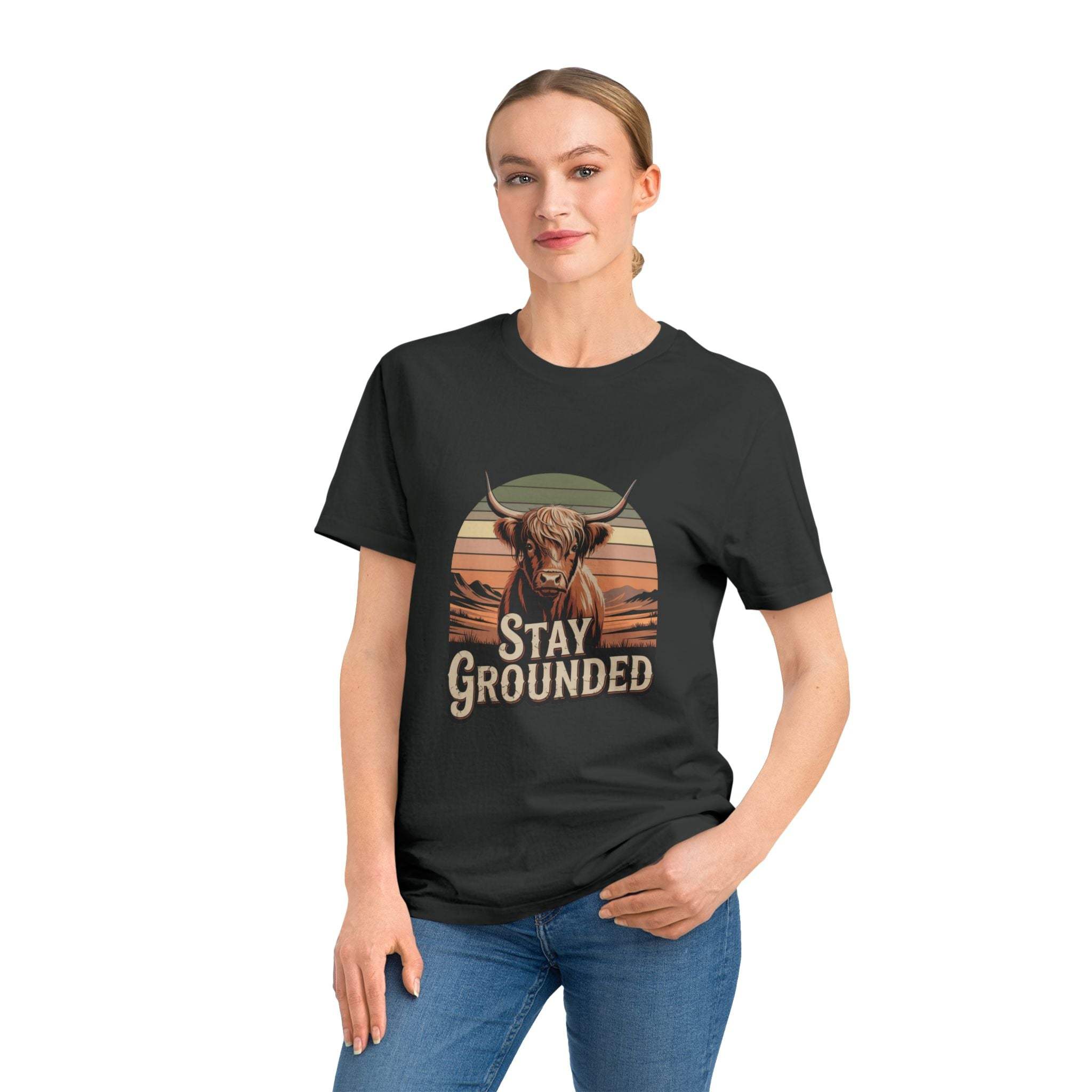 Woman wearing black organic cotton Stay Grounded Rocker T-Shirt with bull graphic and text, paired with blue jeans.