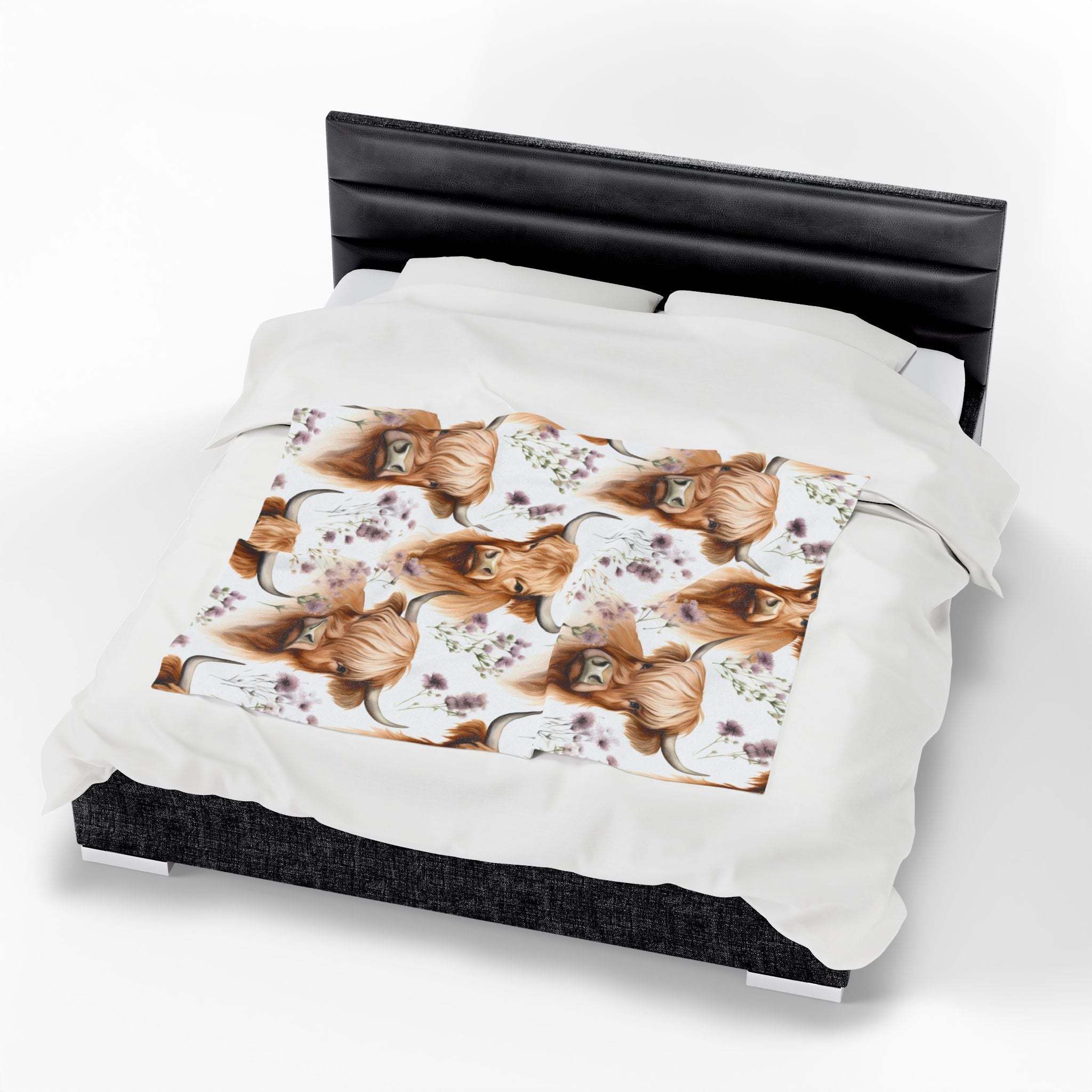 Cozy white plush blanket with floral Highland cow design on bed