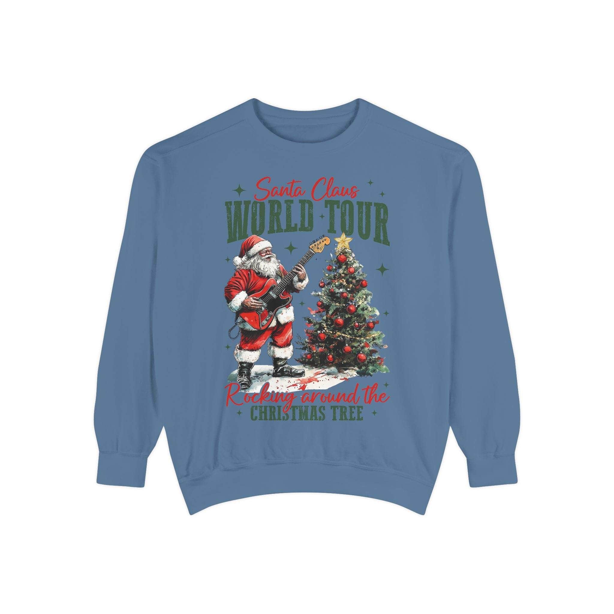 Blue Sweatshirt Rocking Santa playing guitar next to decorated Christmas tree with World Tour text