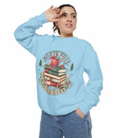 Woman wearing light blue Vintage North Pole Book Club sweatshirt with holiday-themed book stack design
