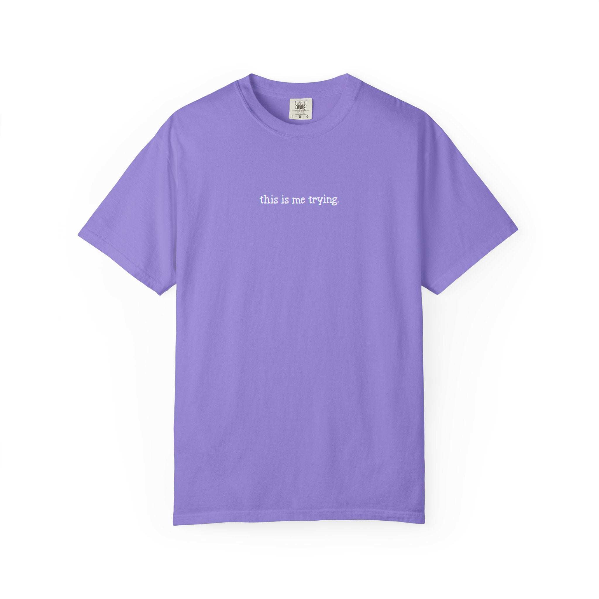 Purple t-shirt with 'this is me trying' text on a white background