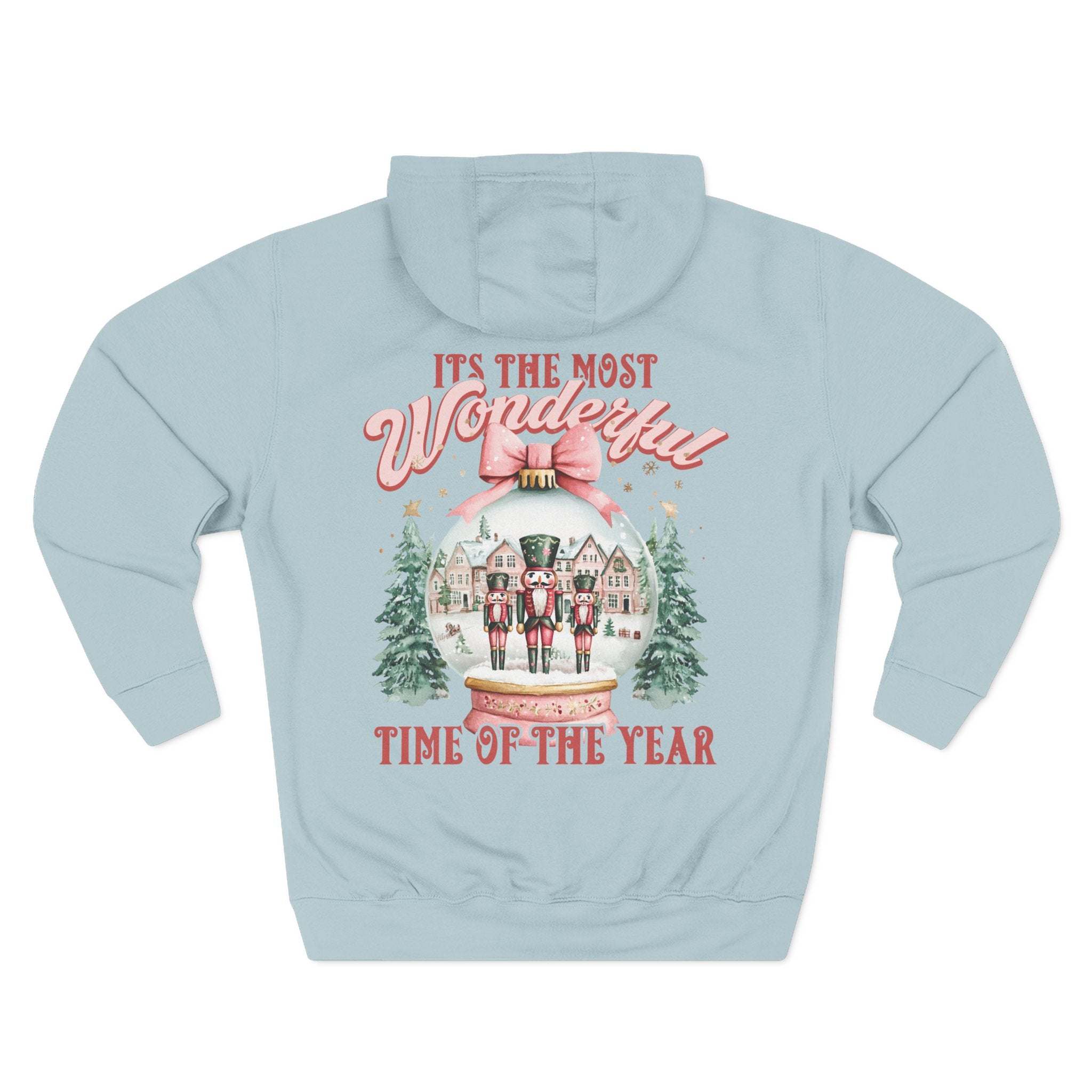Light blue fleece hoodie with vintage pink snow globe and nutcracker design, festive winter holiday style