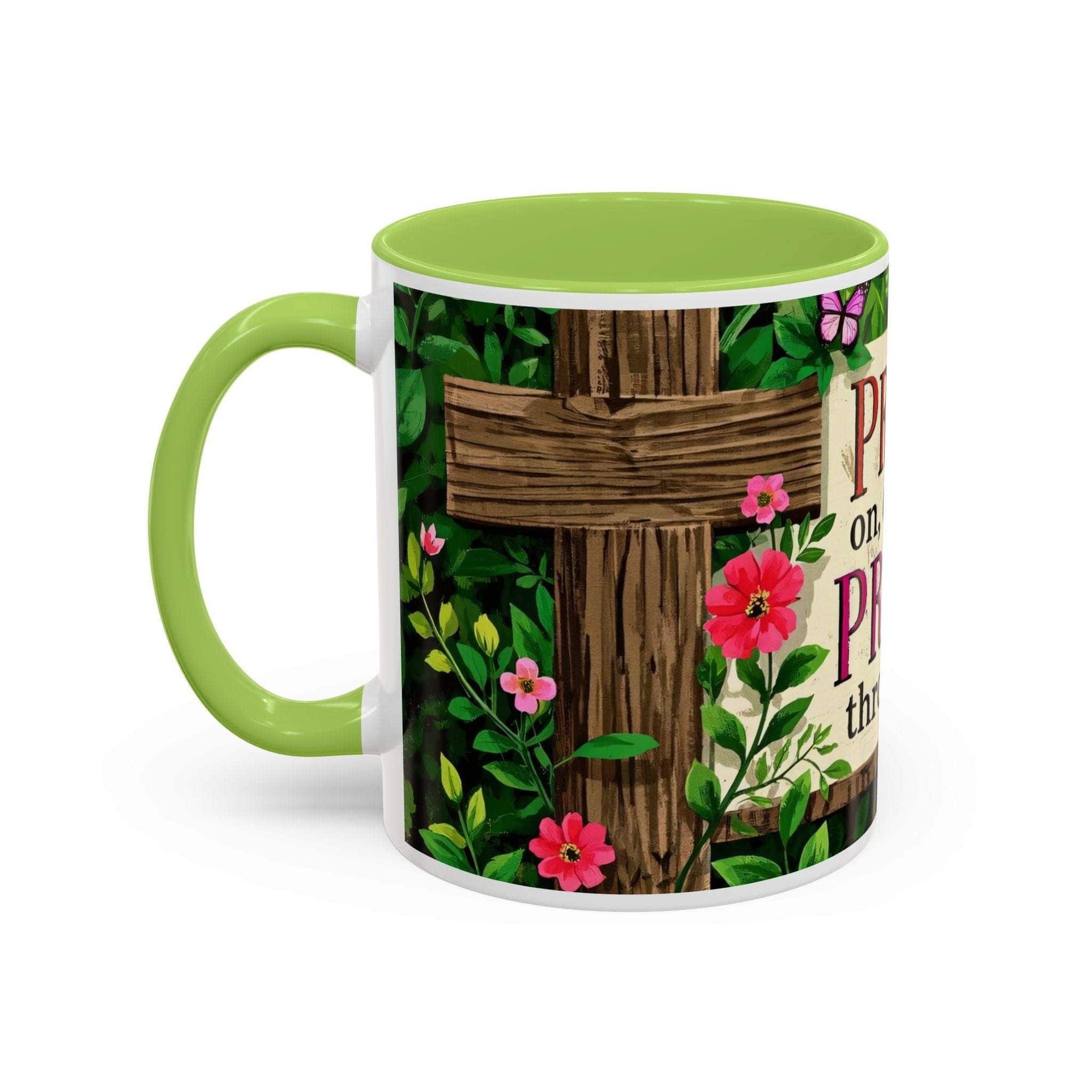 Mug with green handle and floral design featuring a wooden cross and flowers on a white background
