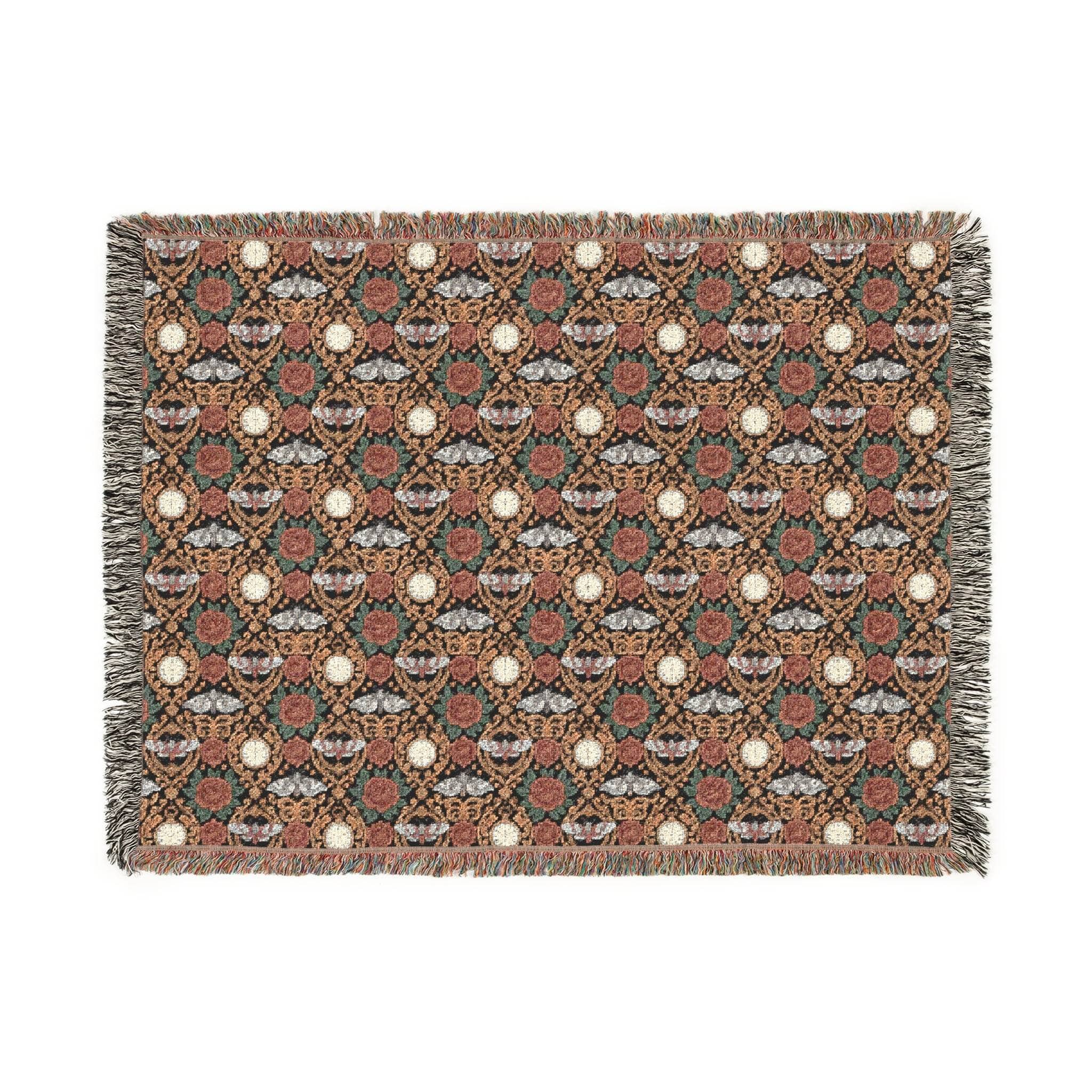 Victorian Gothmas Woven Blanket with candlelight colors and colorful fringed edges draped on a dark velvet bed