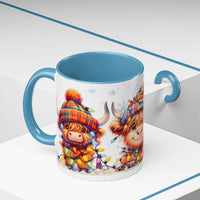 Scottish Highland Cow Christmas coffee mug with colorful holiday hat and lights, blue handle and interior ceramic cup