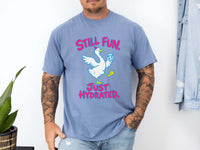 Male model wearing blue jean Comfort Colors crewneck t-shirt featuring a graphic of a white goose holding a blue water bottle, with the pink text 'STILL FUN. JUST HYDRATED.