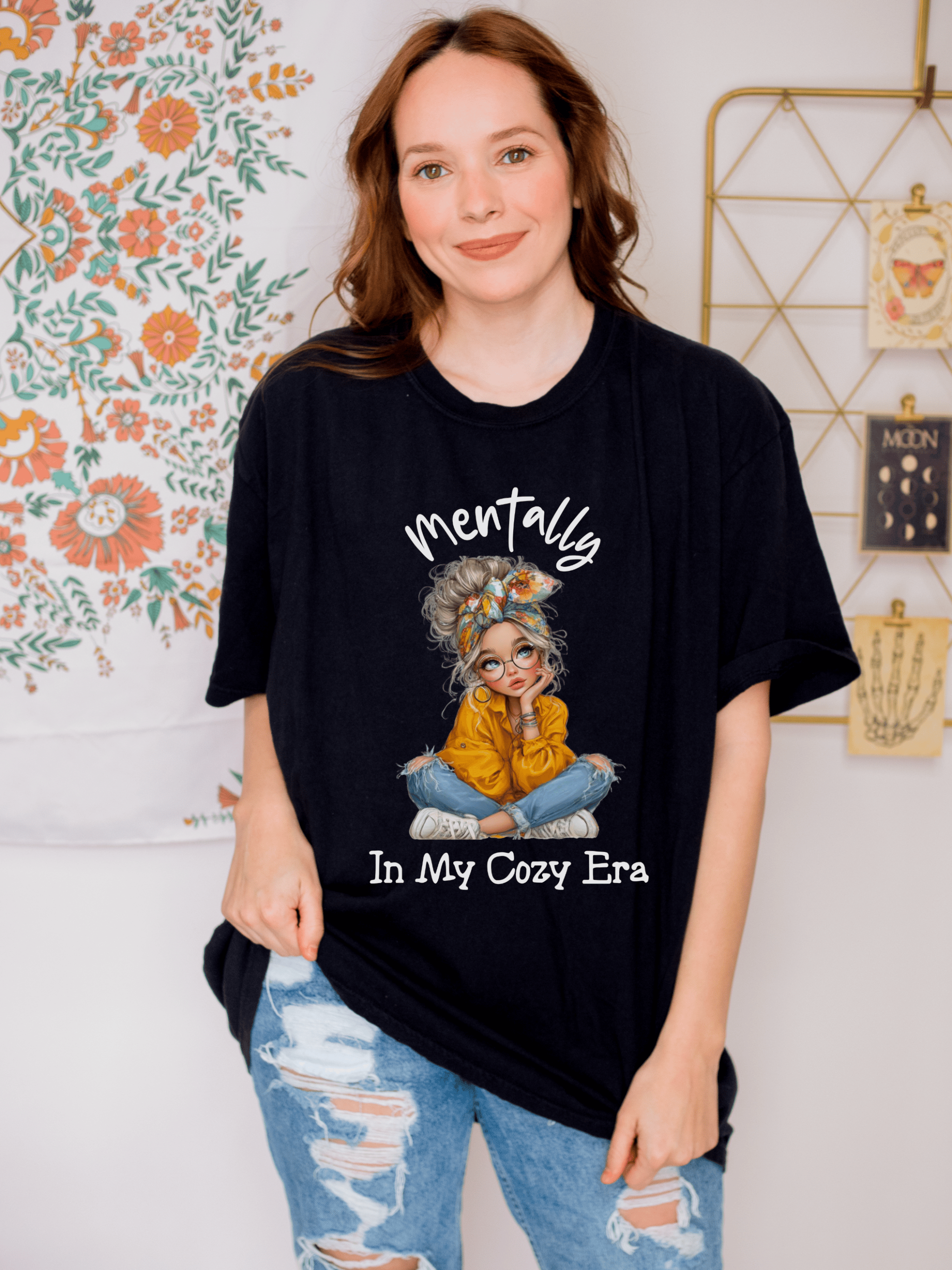Black "Mentally In My Cozy Era" t-shirt with relaxed fit and graphic girl design, styled casually with distressed jeans.