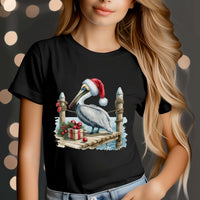 Youth t-shirt featuring pelican tipping Santa hat on coastal pier for festive holiday wear