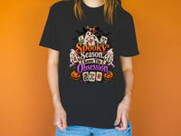 Model wearing a black Halloween mahjong T-shirt with ghosts, pumpkins, mahjong tiles and “Spooky Season, Same Tile Obsession” lettering.