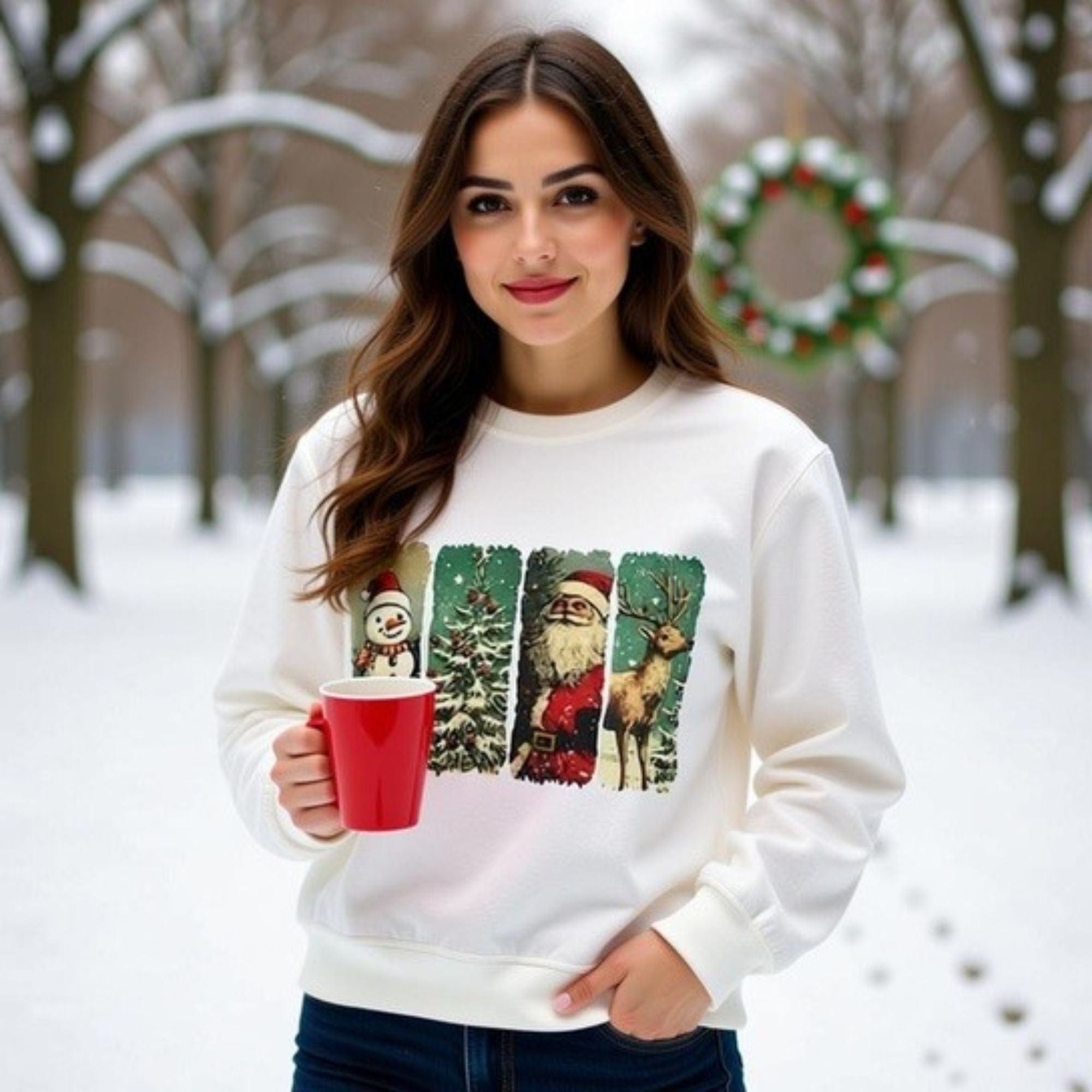 Woman wearing vintage Christmas sweatshirt with watercolor holiday characters holding red mug outdoors in snowy park