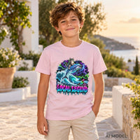 Boy wearing a light pink Local Legend kids T-shirt with a neon cat and dolphin graphic in a coastal villa garden at sunset.