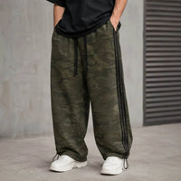 Unisex camo wide leg sweatpants with olive camouflage, black side webbing, elastic waistband, adjustable drawstring cuffs, and relaxed streetwear fit