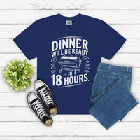 Dinner Will Be Ready in 18 Hours meat smoker t-shirt in navy with white text, paired with jeans and sneakers on white wood background