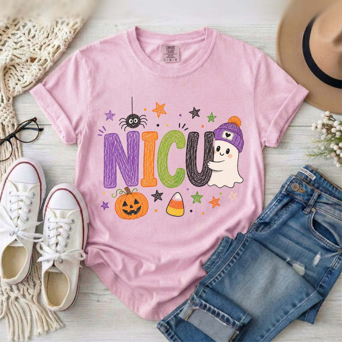 Blossom Pink NICU nurse Halloween T-shirt with colorful crayon-style lettering, a smiling ghost in a purple beanie, pumpkin, and candy corn.