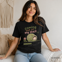 A woman sitting on a white couch wearing a black graphic t-shirt with a cute cartoon snail design and the text 'coming out of my shell (please wait)'.