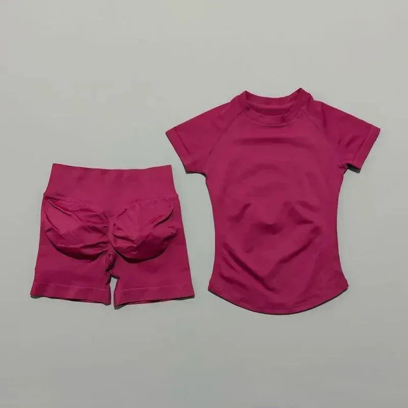 Woman wearing seamless short-sleeve yoga top and high-waisted workout shorts from Impact Sports Sets in coordinated athletic style