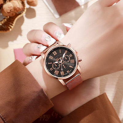 Women's fashion watch with black Roman numeral dial and rose gold stainless steel mesh strap on wrist