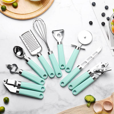 Household stainless steel kitchen tools set with turquoise handles including grater, whisk, peeler, pizza cutter, can opener, garlic press, bottle opener, and knife on marble countertop