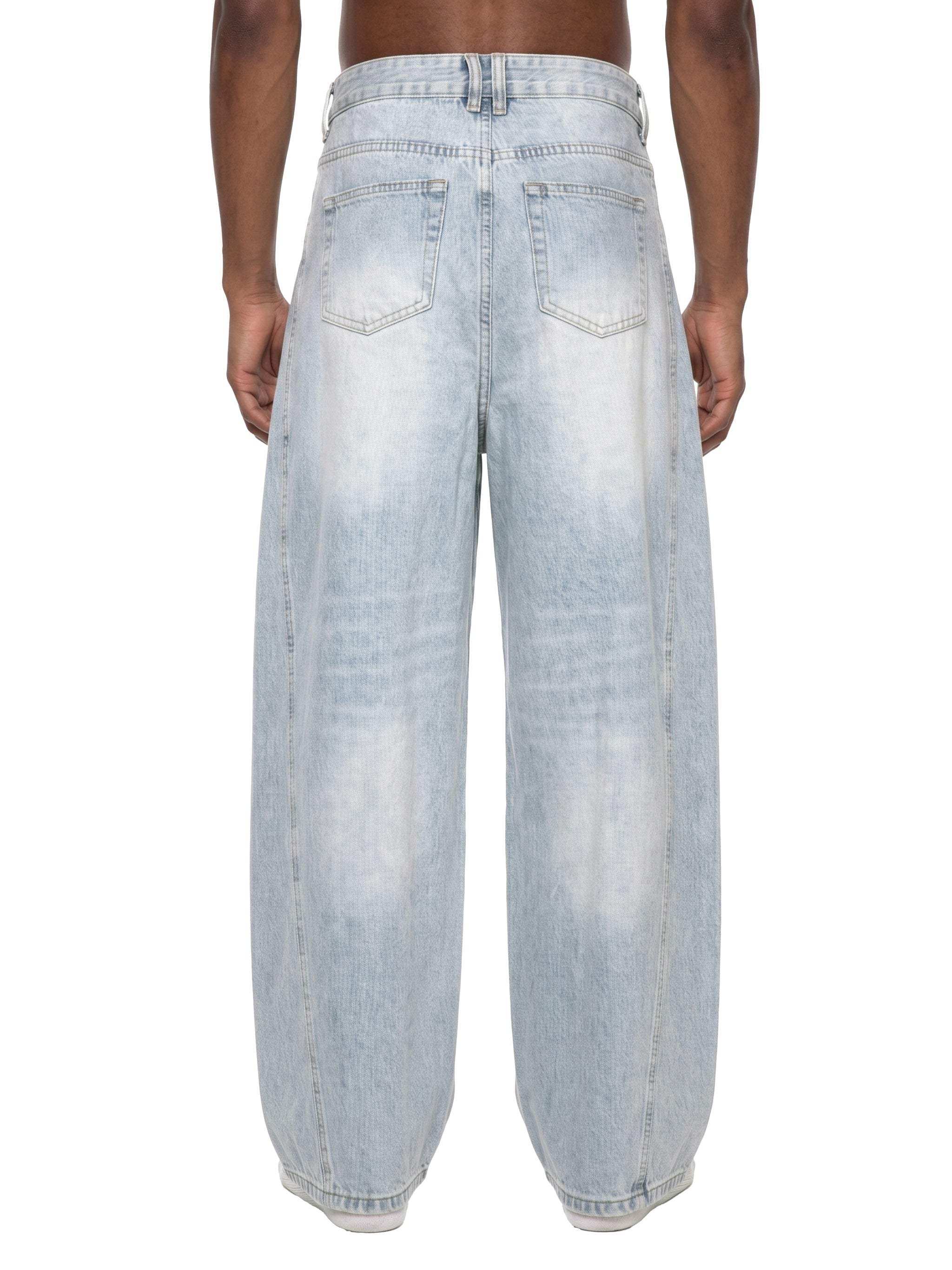 Men's vintage wash sunfade barrel leg jeans with frayed details and relaxed fit on model