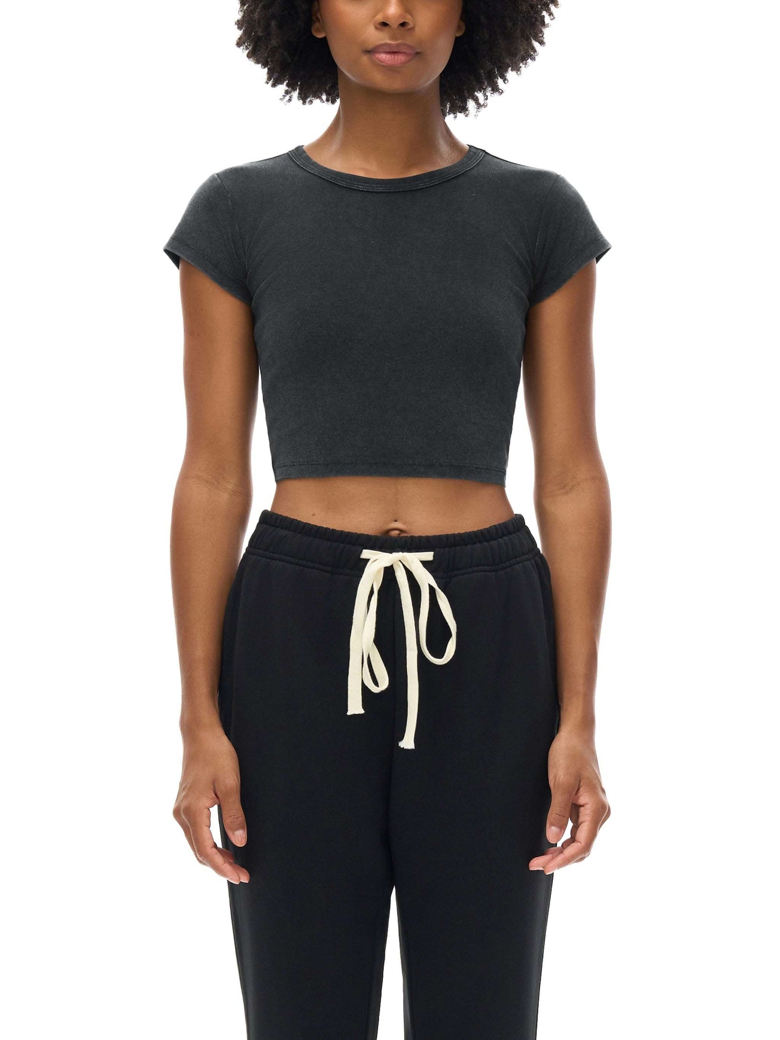 Women wearing a snow washed crop top with round neck and drop shoulder sleeves in casual streetwear style