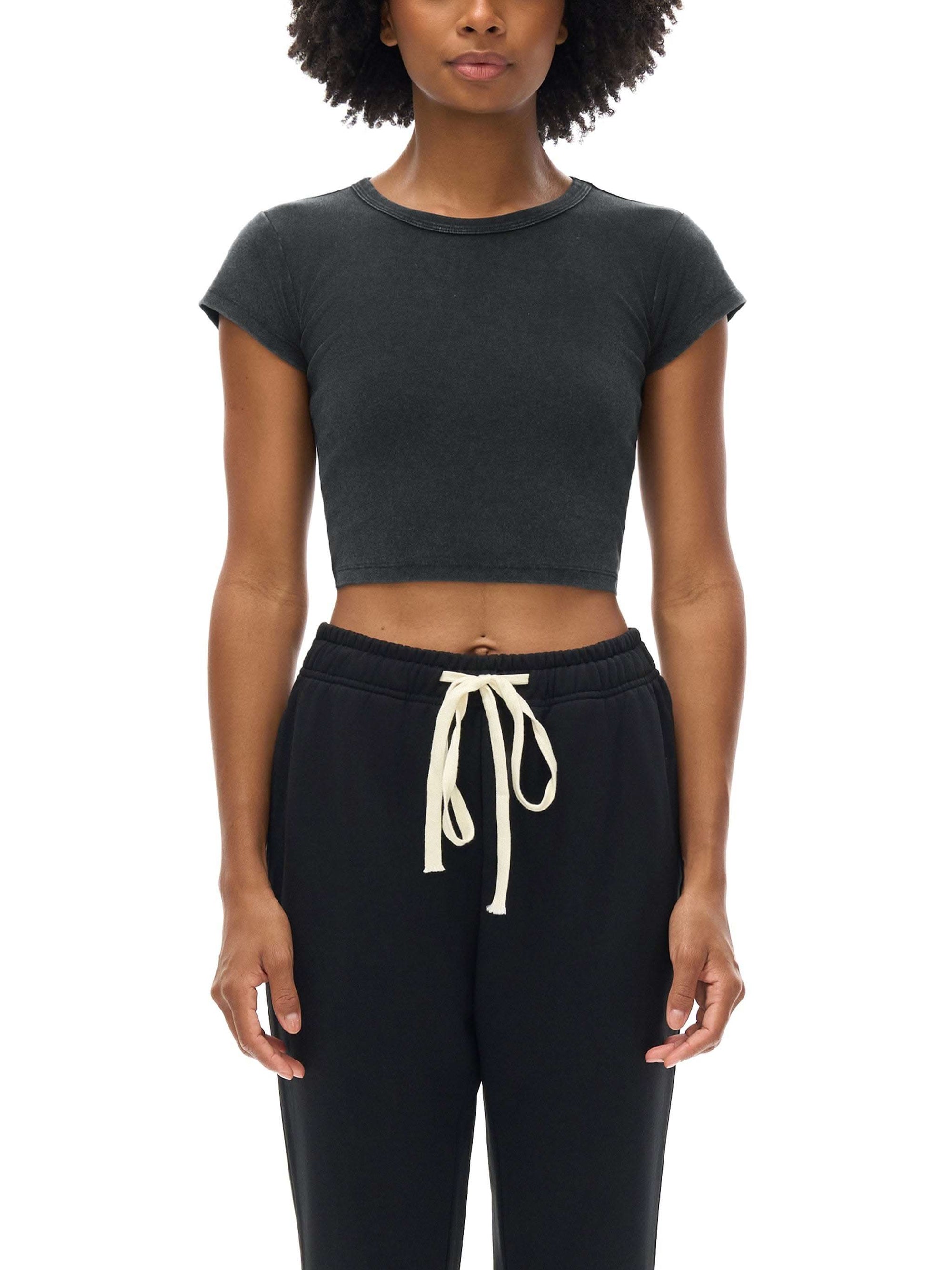 Women wearing a snow washed crop top with round neck and drop shoulder sleeves in casual streetwear style