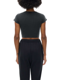 Women wearing a white snow washed crop top with drop shoulder sleeves and round neck, styled casually for spring and summer