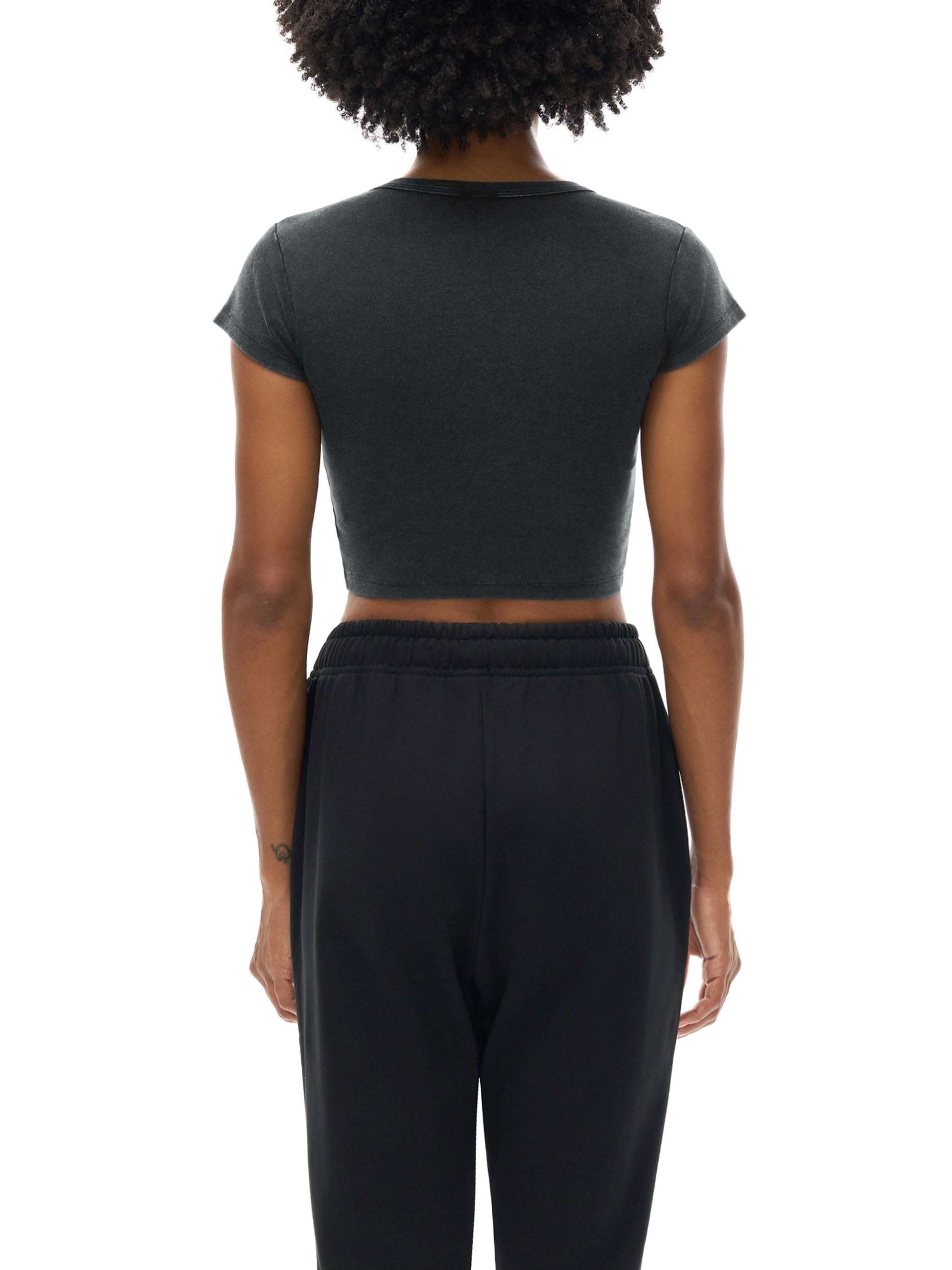 Women wearing a white snow washed crop top with drop shoulder sleeves and round neck, styled casually for spring and summer