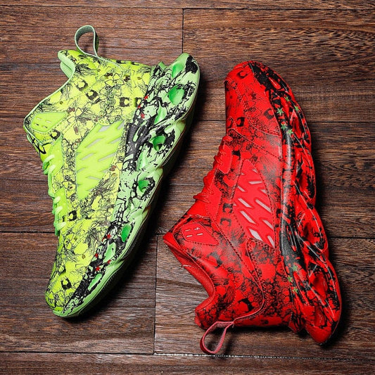 Pair of trendy camouflage sports shoes in neon green and red colors with low flat heels and front tie design on wooden floor