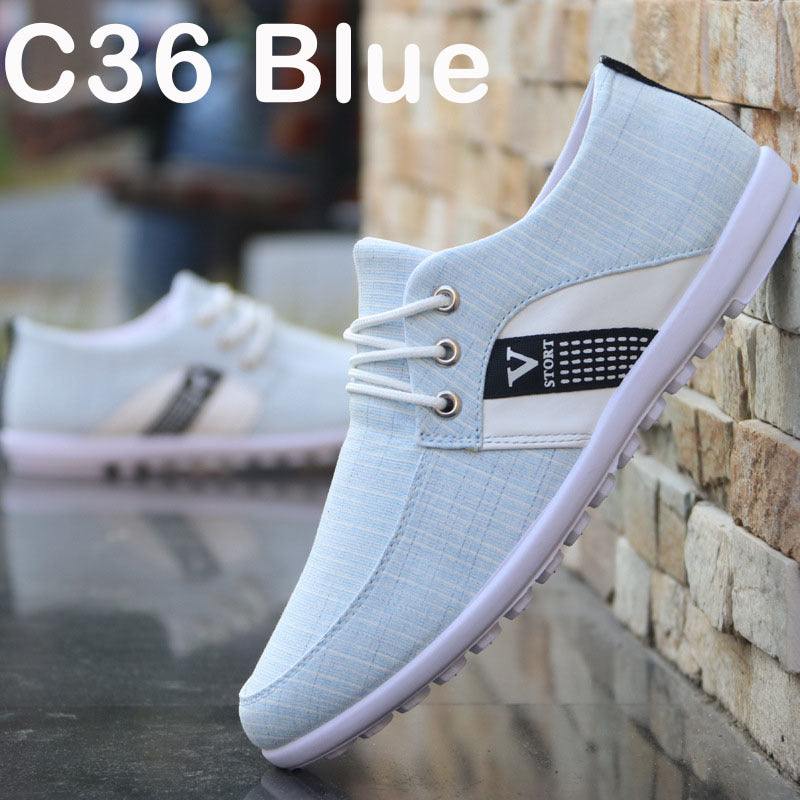 Men's soft-soled blue canvas shoe with round toe and leisure style against stone wall background