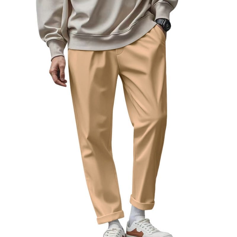 Men's beige casual loose-fit trousers with pockets and drawstring waist, paired with white sneakers and a light sweatshirt.