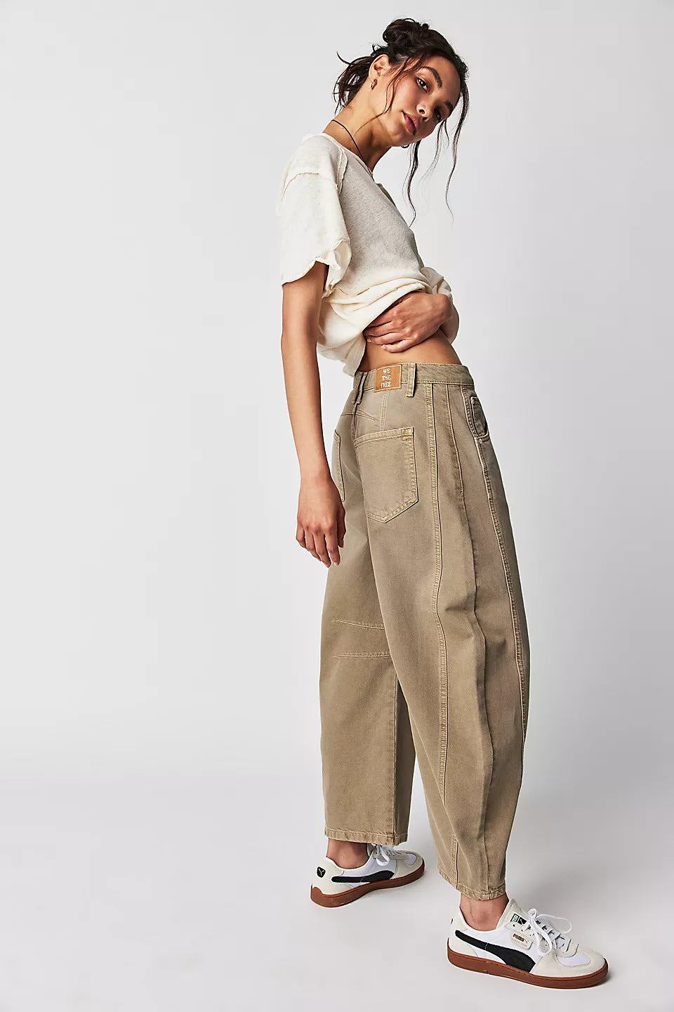 Women wearing high stretch mid-rise loose wide leg khaki denim jeans with casual white t-shirt and sneakers