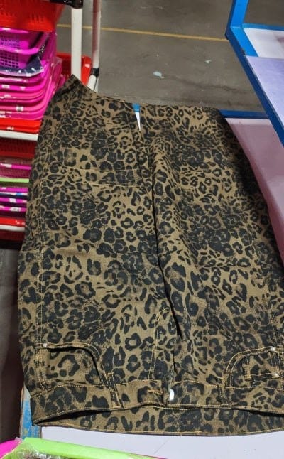 Leopard print high stretch mid-rise wide leg denim jeans laid flat on table