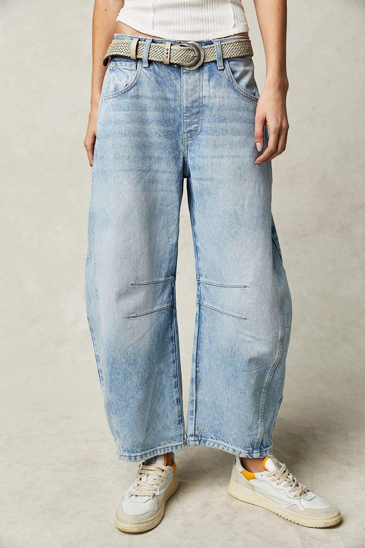 Women’s high stretch mid-rise light blue wide-leg baggy denim jeans with belt and casual sneakers