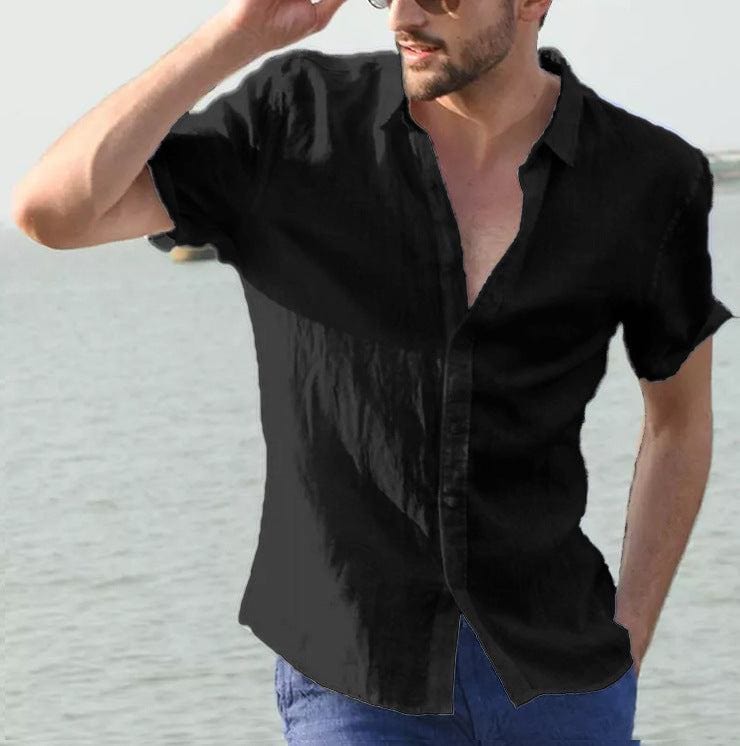 Man wearing black summer short-sleeved casual button-up shirt with lapel collar by the water