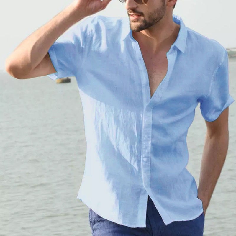 Man wearing light blue summer short-sleeved casual button-up shirt with lapel collar outdoors near water