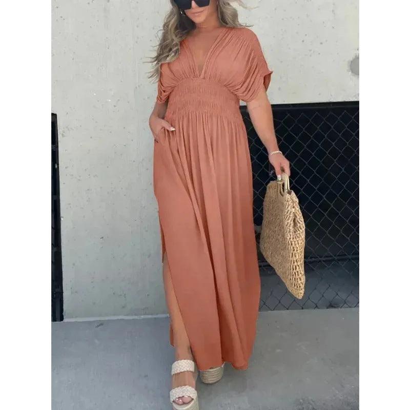 Woman wearing a brown bat-sleeved V-neck slit summer dress with elastic waist holding a woven bag