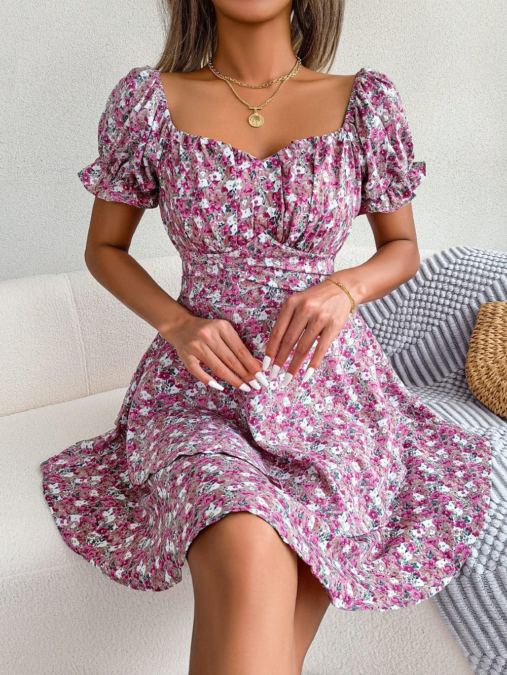 Women mini dress with floral print, puffed short sleeves, ruched bodice, and loose A-line skirt in pink and purple tones