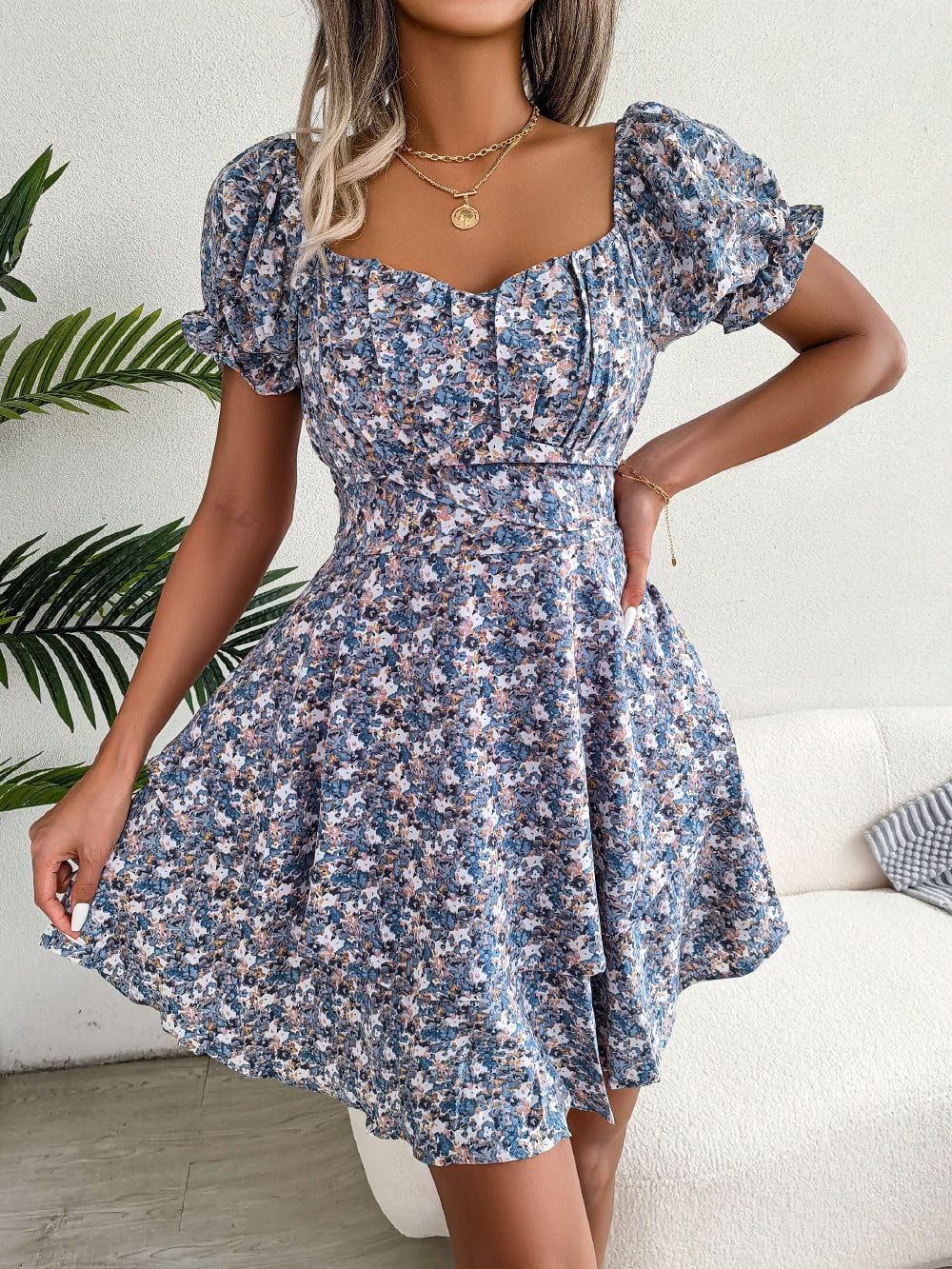 Women mini dress with floral print, short puff sleeves, high waist, and loose A-line skirt design.