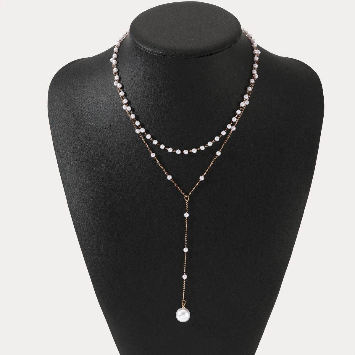 Pearl double layer twin pearl necklace with geometric alloy pendant and cross chain design on black display bust